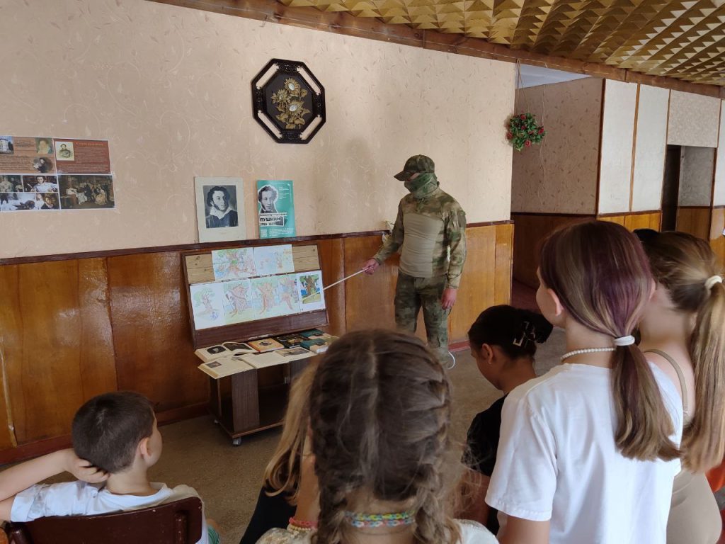 Чоловік у військовій формі та балаклаві проводить захід для дітей в окупованому Росією селищі Сиваське Херсонської області 