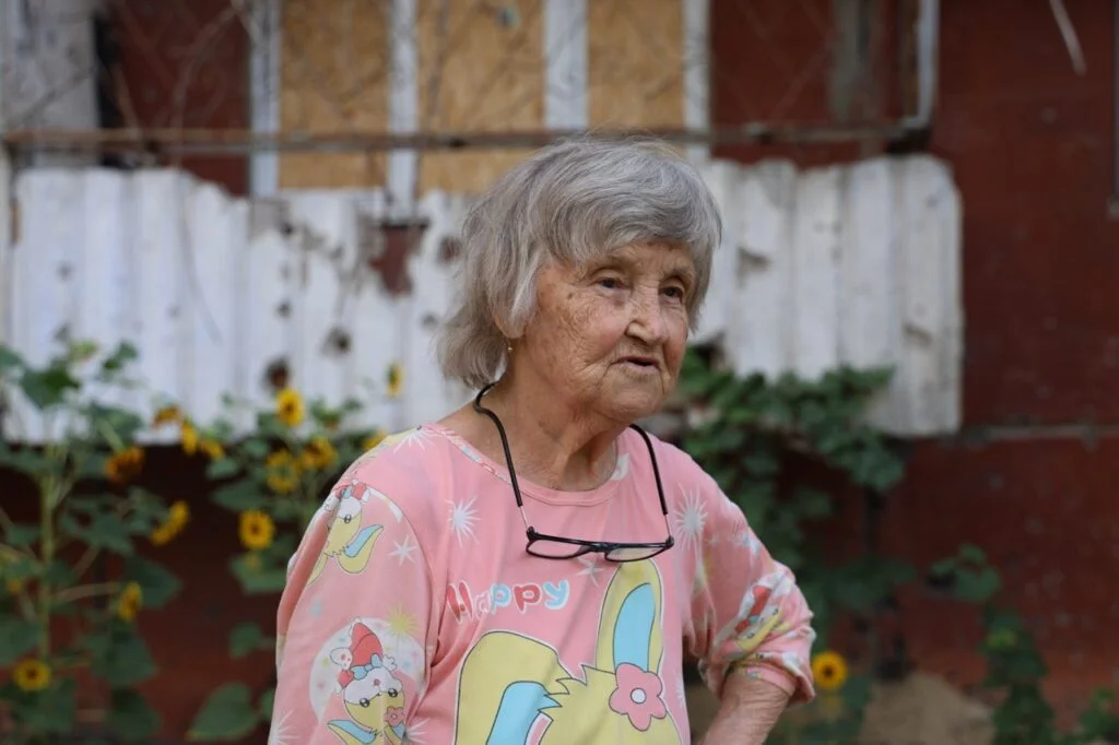 Літня жінка з окулярами на шиї