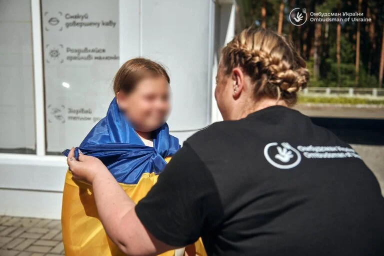 Дівчинку з Херсонщини, яка не могла виїхати через втрату документів, повернули з окупації Жінка загортає дитину в український прапор