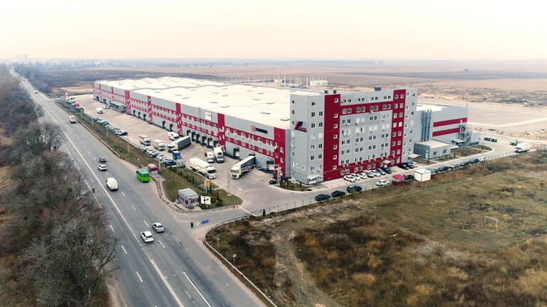 Великий складський комплекс із вантажівками біля дороги