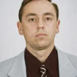 Чоловік у світлому піджаку на нейтральному тлі