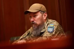 Військовий у камуфляжі сидить за столом