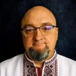 Чоловік в окулярах у білій вишиванці
