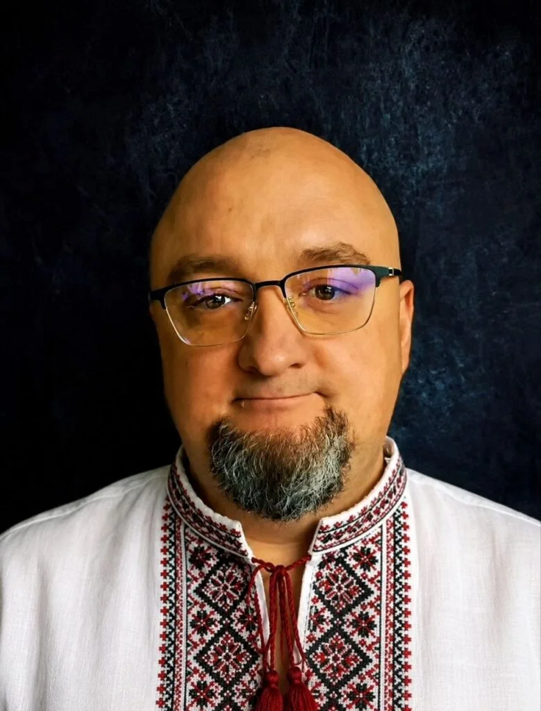 Чоловік в окулярах у білій вишиванці
