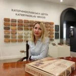 Жінка сидить у залі музею цегли
