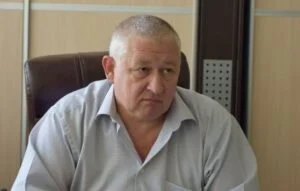 Чоловік у світлій сорочці сидить у кабінеті
