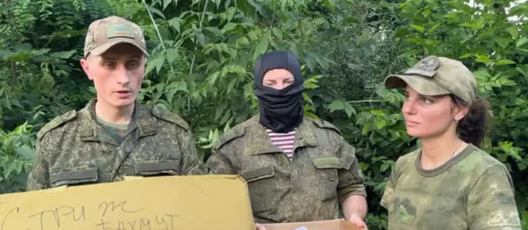 Троє людей у військовій формі на тлі зелені
