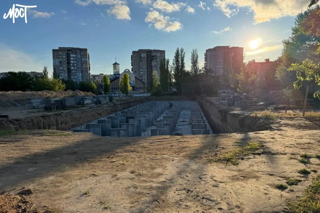 Котлован на будівельному майданчику серед житлових будинків