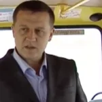 Чоловік у костюмі стоїть у салоні автобуса